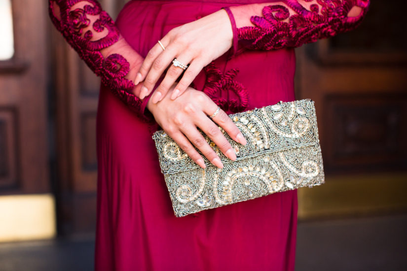 Vintage Bridesmaid dress in red with model holding a clutch and wearing Kirk Kara rings