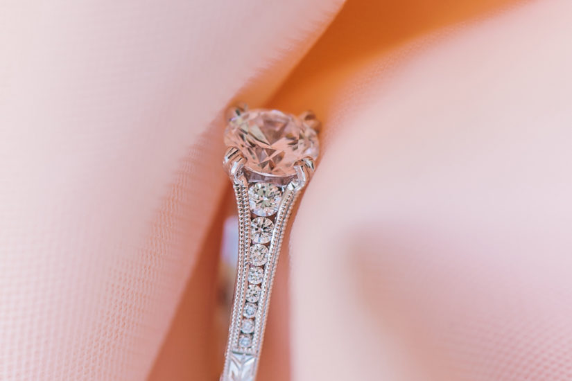 White gold and diamond engagement ring on a soft pink fabric background